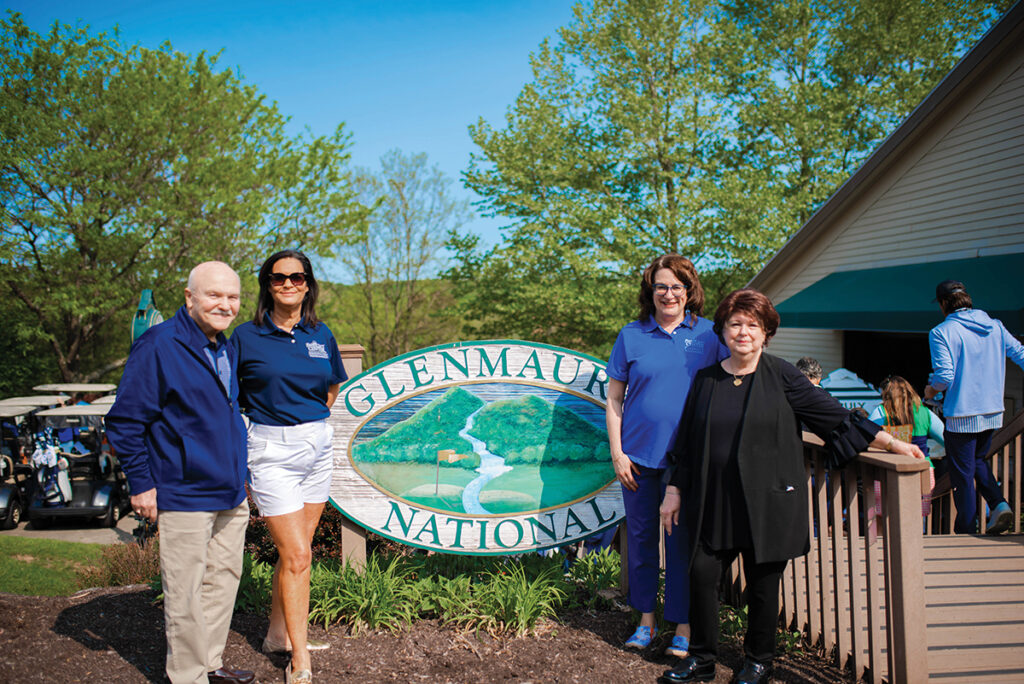 El presidente/director general y los miembros del consejo de administración de Wright Centers ante el cartel del Glenmaura National Golf Course.